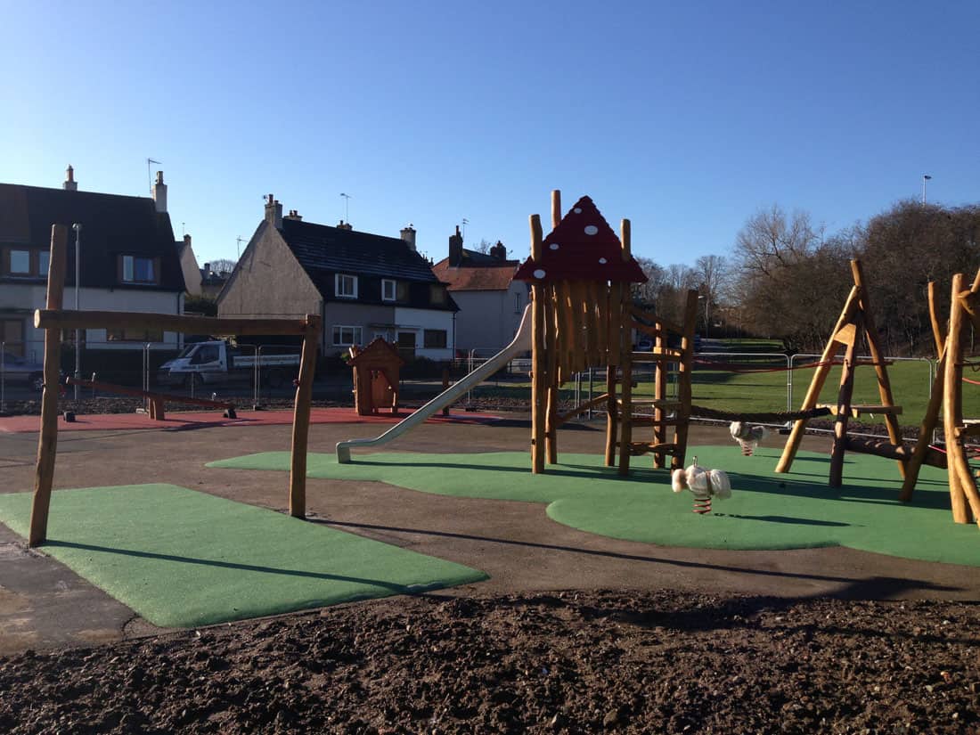 Playground with big woods and artificial grass